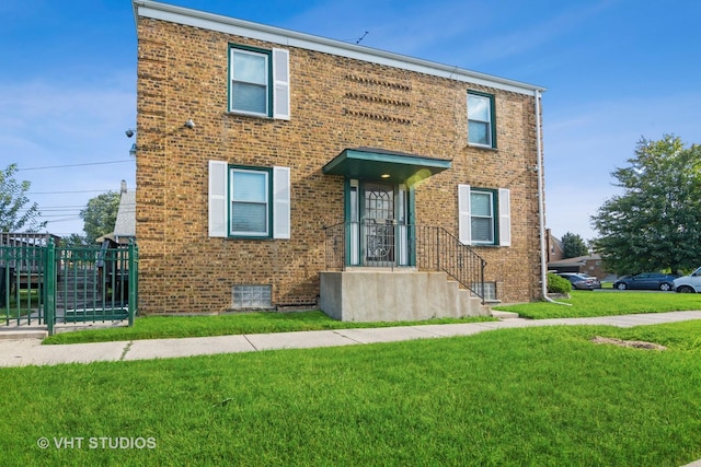 view of front of property with a front lawn and brick siding