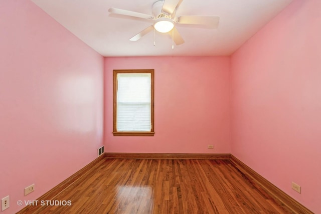 empty room with visible vents, baseboards, wood finished floors, and a ceiling fan