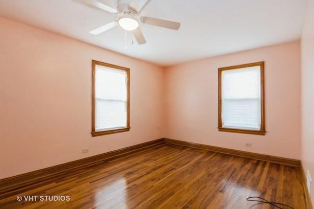 empty room with baseboards, dark wood-type flooring, and ceiling fan