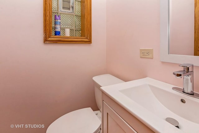 half bathroom with vanity and toilet