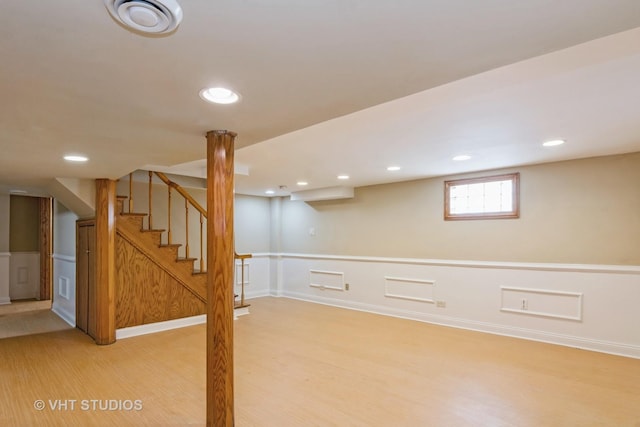 basement featuring stairway, recessed lighting, light wood finished floors, and wainscoting