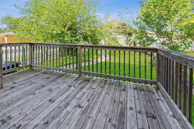 wooden terrace featuring a lawn