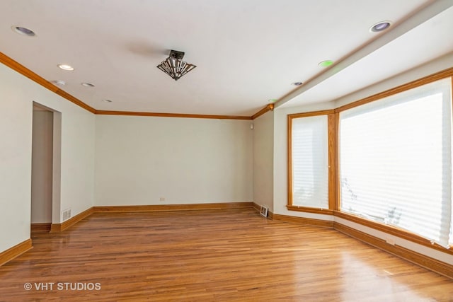 unfurnished room featuring visible vents, baseboards, light wood-type flooring, ornamental molding, and recessed lighting