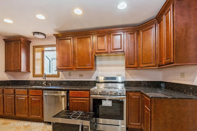 kitchen featuring a sink, dark stone countertops, recessed lighting, stainless steel appliances, and light tile patterned flooring