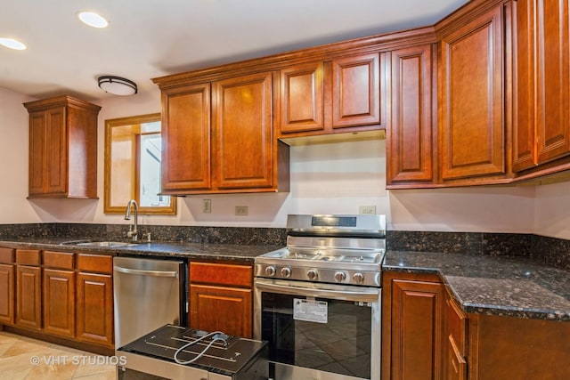 kitchen featuring dark stone counters, light tile patterned floors, recessed lighting, appliances with stainless steel finishes, and a sink