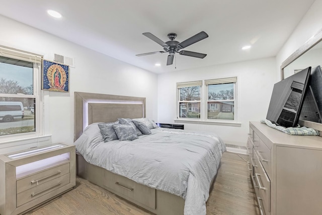 bedroom featuring multiple windows, ceiling fan, and light wood-type flooring