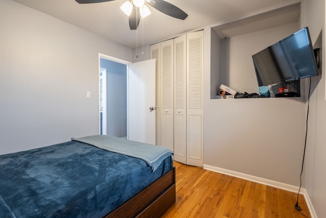 bedroom with a closet, light hardwood / wood-style flooring, and ceiling fan