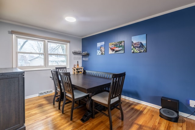 dining space featuring light hardwood / wood-style floors and ornamental molding