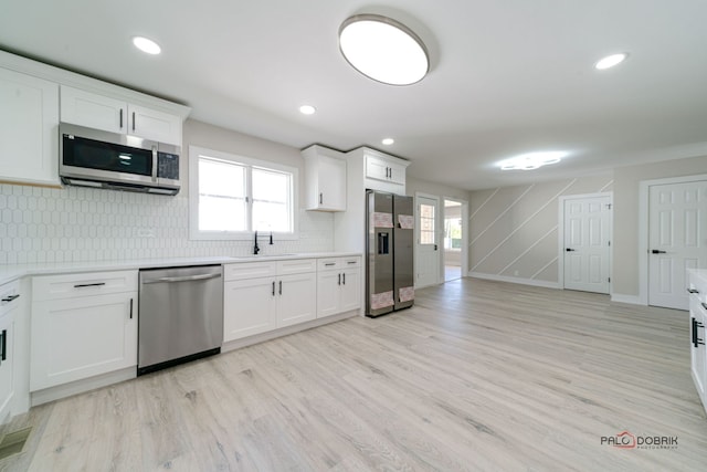 kitchen featuring light hardwood / wood-style flooring, white cabinets, stainless steel appliances, and sink