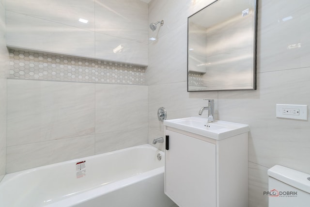 full bathroom with tile walls, vanity, bathtub / shower combination, and toilet