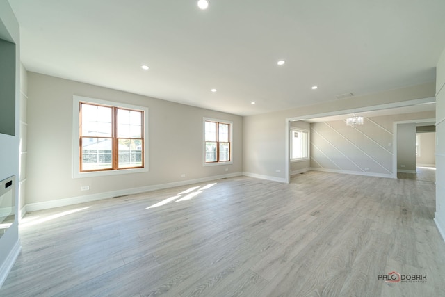 spare room featuring light hardwood / wood-style floors and an inviting chandelier