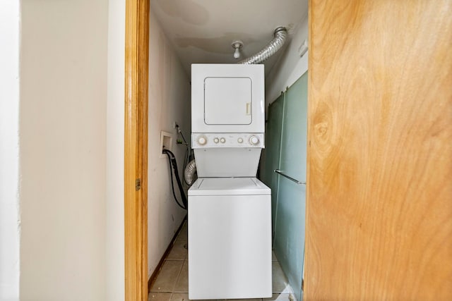 washroom featuring light tile patterned floors and stacked washing maching and dryer