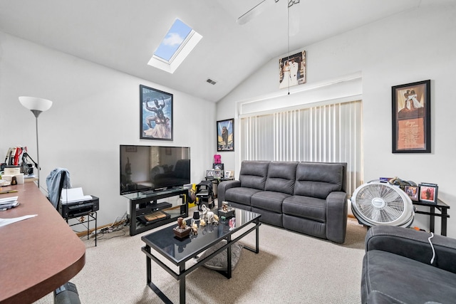 carpeted living room featuring vaulted ceiling with skylight and ceiling fan