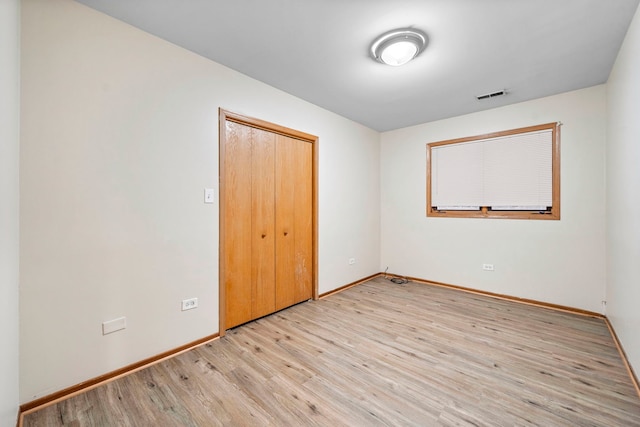 unfurnished bedroom featuring a closet and light hardwood / wood-style floors