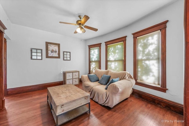 living room featuring dark wood-type flooring and ceiling fan