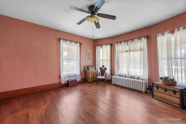 unfurnished room with radiator, dark hardwood / wood-style floors, and ceiling fan