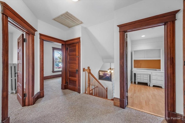 hall with radiator and light colored carpet