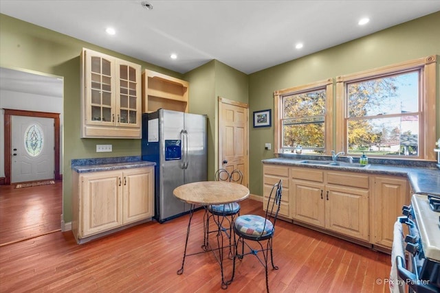 kitchen featuring stove, sink, stainless steel fridge, and light wood-type flooring