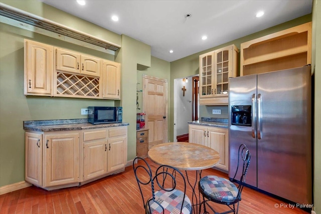 kitchen with light wood-type flooring and stainless steel fridge with ice dispenser