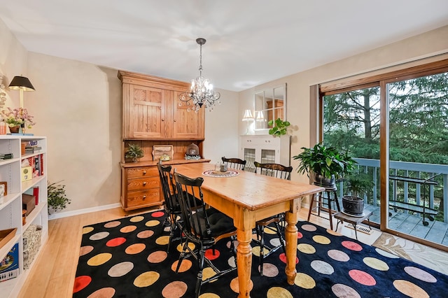 dining room with light hardwood / wood-style flooring and a notable chandelier