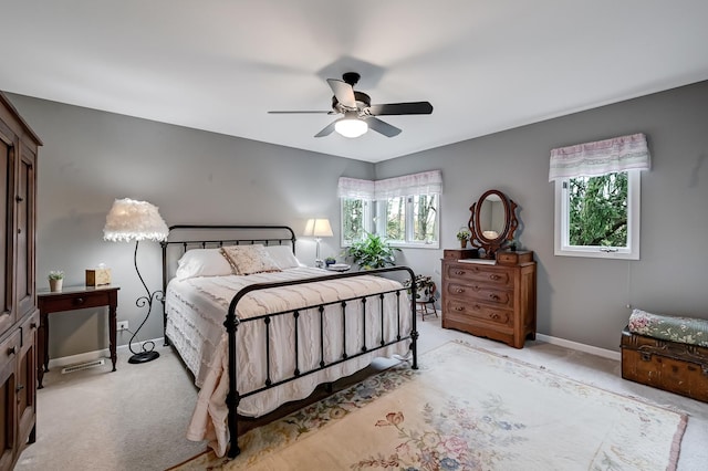 carpeted bedroom featuring multiple windows and ceiling fan