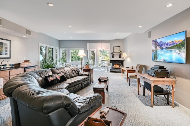 living room featuring sink, light colored carpet, and a notable chandelier