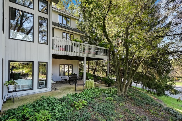 back of property featuring a balcony and a patio