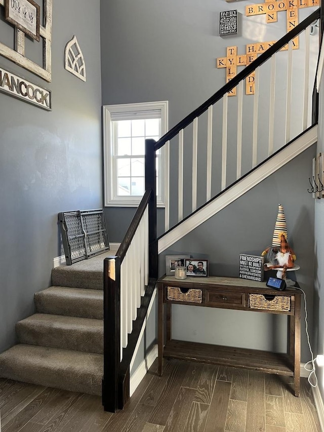 stairway featuring hardwood / wood-style floors and a high ceiling