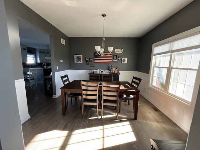 dining space featuring a chandelier, dark wood-type flooring, and sink