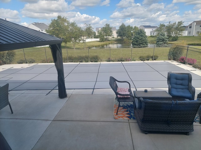 view of patio with a gazebo and a water view