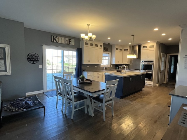 dining room with sink, dark hardwood / wood-style flooring, and a notable chandelier