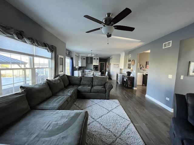 living room featuring ceiling fan and dark wood-type flooring