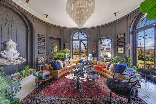 sitting room with a chandelier, a decorative wall, and crown molding