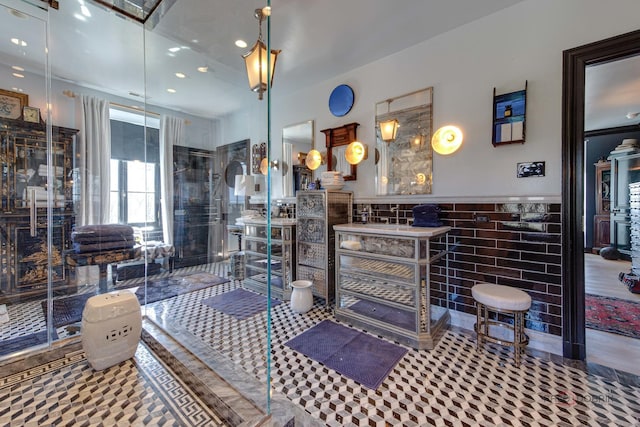 bathroom featuring a wainscoted wall, tile walls, and recessed lighting