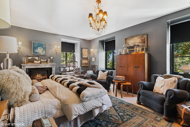 bedroom featuring a premium fireplace and an inviting chandelier