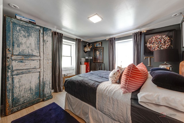 bedroom featuring multiple windows and light wood-style flooring