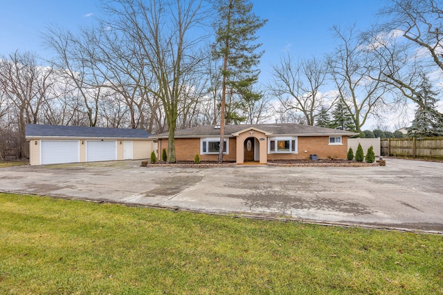 ranch-style house with a garage, an outbuilding, and a front lawn