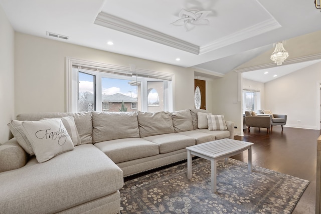 living room featuring ceiling fan with notable chandelier, dark hardwood / wood-style flooring, a tray ceiling, and crown molding