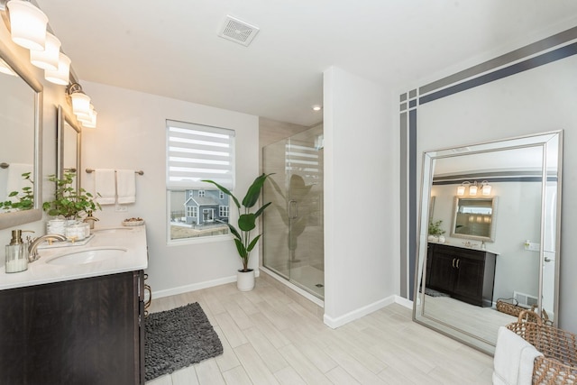 bathroom featuring hardwood / wood-style flooring, a shower with door, a fireplace, and vanity