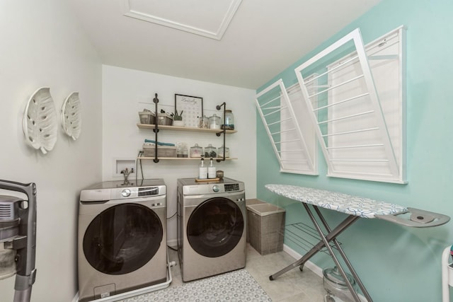 clothes washing area featuring washing machine and dryer and light tile patterned floors