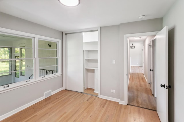 unfurnished bedroom featuring light hardwood / wood-style floors and a closet