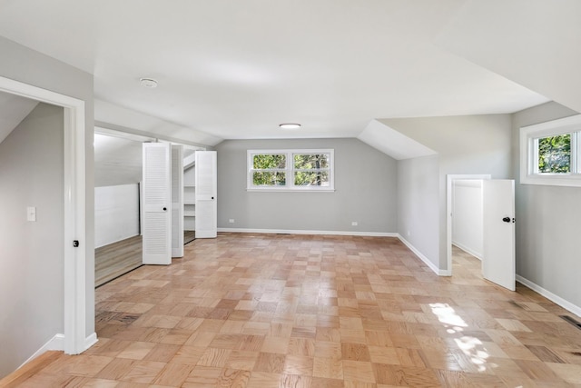 bonus room featuring light parquet floors, a wealth of natural light, and vaulted ceiling