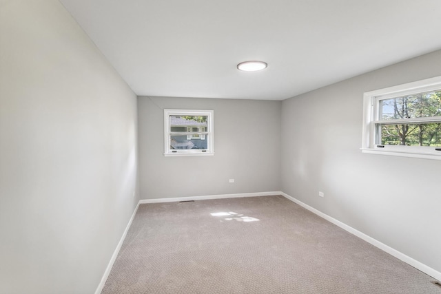 empty room with carpet flooring and a healthy amount of sunlight