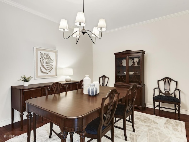 dining room with wood-type flooring, ornamental molding, and a chandelier