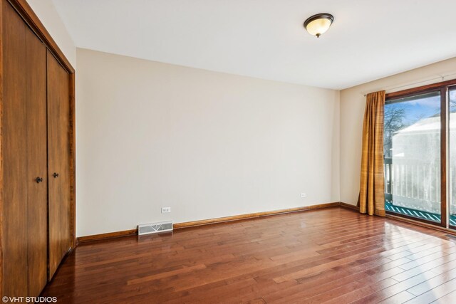 unfurnished bedroom featuring a closet and hardwood / wood-style floors