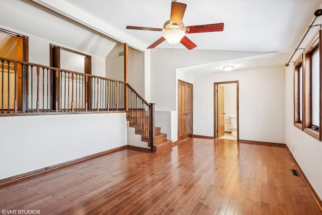 unfurnished living room featuring ceiling fan, wood-type flooring, and vaulted ceiling