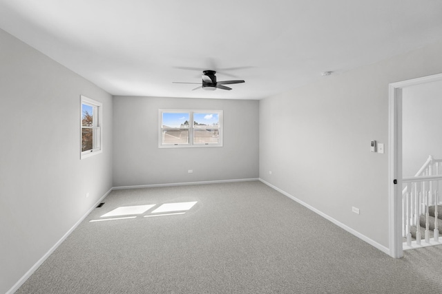 carpeted spare room featuring ceiling fan