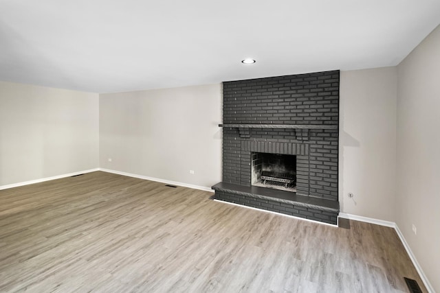 unfurnished living room featuring a fireplace and light wood-type flooring