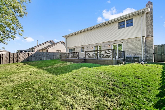 rear view of property with a deck and a lawn