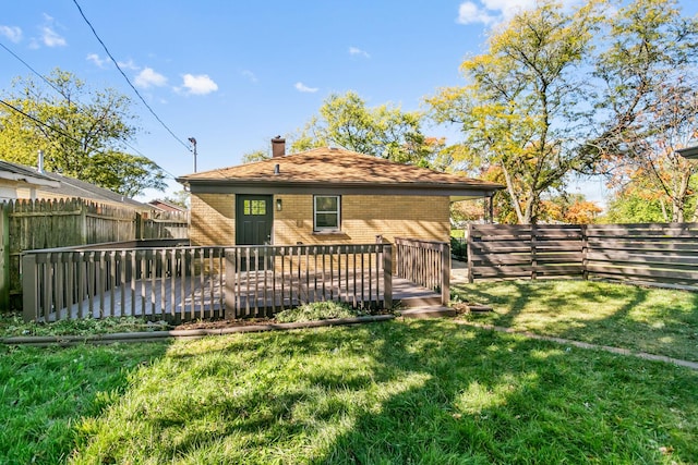 back of property featuring a lawn and a deck